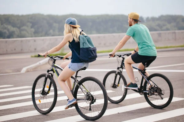 Vista trasera de una feliz pareja caminando en bicicleta — Foto de Stock