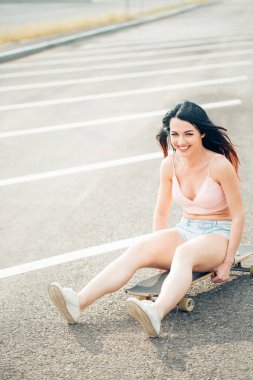 Kot gömlekli sıradan sarışın kadın merdivenlerde uzun tahtalı poz veriyor.