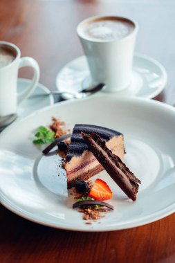 İçiniz rahat katmanlı sufle tatlısı tabakta ahşap masa üzerinde çikolata sos ile