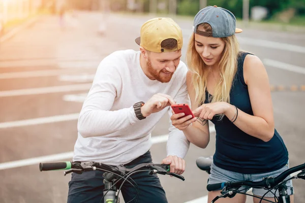 Couple à vélo regardant téléphone. Homme et femme en voyage par téléphone portable . — Photo