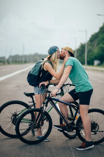 자전거와 함께 산책 하 고, 키스 하 고 포옹 사랑에 아름 다운 젊은 부부 — 스톡 사진