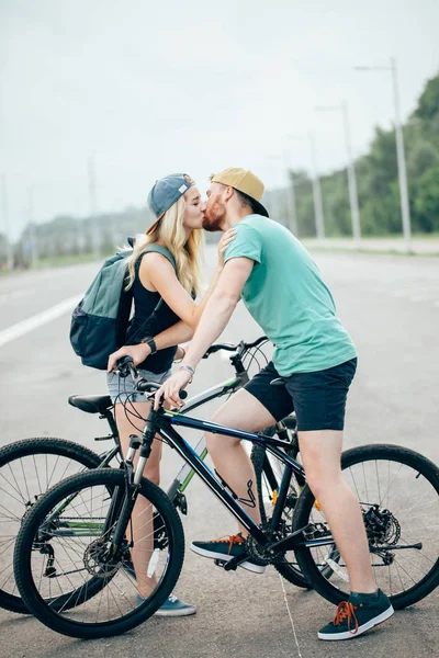 Beau jeune couple amoureux marchant à vélo, embrassant et embrassant — Photo