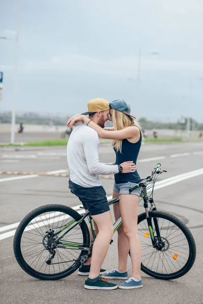 Romantyczny sportowych para Całowanie przed niewyraźne tło z rowerami — Zdjęcie stockowe
