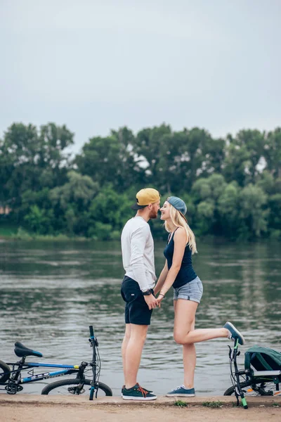 Romantik Çift göl günbatımı rahatlatıcı Bisikletleri ile. Aşk kavramı düşmek.