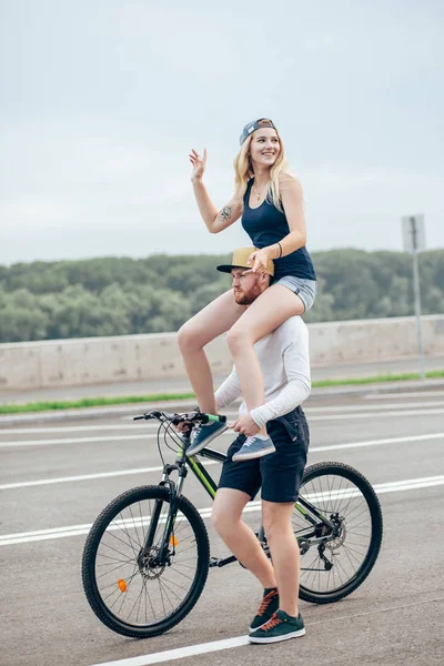 Couple à vélo dans le parc, souriant et petite amie sur l'épaule — Photo