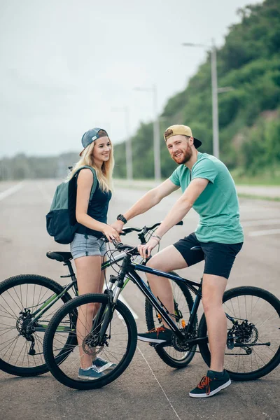 Para młoda hipster, trzymając się za ręce stoi na drodze — Zdjęcie stockowe