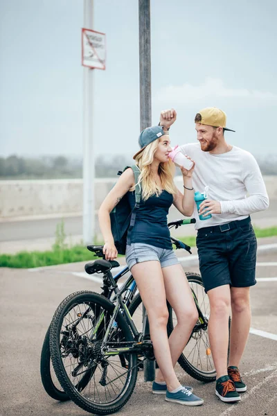 Jeune couple hipster tenant la main debout sur la route — Photo