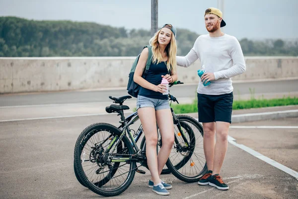 Jeune couple hipster tenant la main debout sur la route — Photo