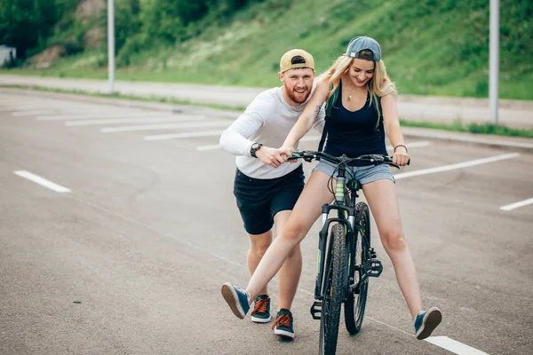 Ο τύπος να διδάξει την κοπέλα να οδηγήσω ένα ποδήλατο — Φωτογραφία Αρχείου