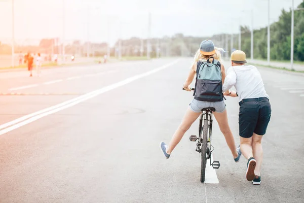 Chico enseñar a su chica a montar en bicicleta — Foto de Stock