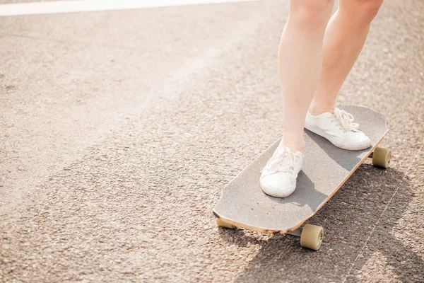 Onun ahşap longboard kaykay aşırı yolculuktan sonra istirahat kadın bacak yakın çekim — Stok fotoğraf