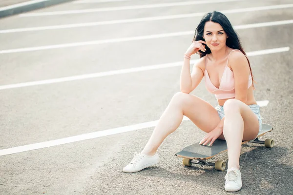 스케이트 보더 소녀 미소입니다. 소식통 여자 스케이트 보드에 앉아 — 스톡 사진