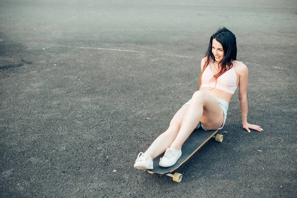 Mujer con longboard sentado en el suelo — Foto de Stock