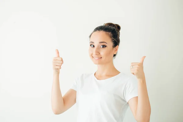 Ευτυχισμένη νεαρή γυναίκα δίνει αντίχειρες επάνω σε λευκό φόντο — Φωτογραφία Αρχείου