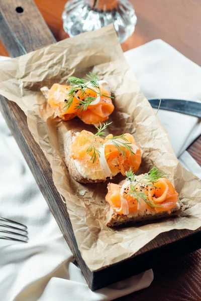 Tahıl ekmek ve karanlık mermer zemin üzerine somon sandviç