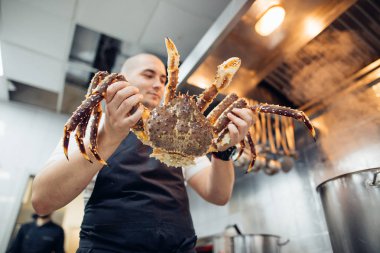 young Chef with Cooked Dungeness Crabs at kitcen clipart