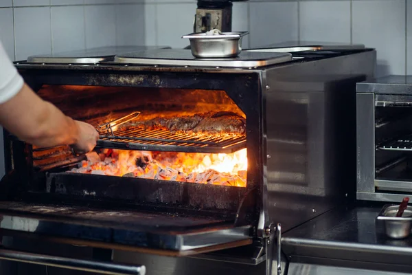 Ízletes marhahús a grillen tűzlángokkal — Stock Fotó