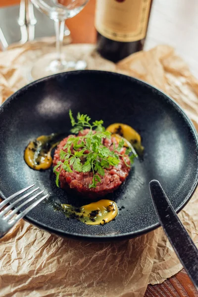 Tártaro de carne de vaca com um ovo em uma chapa de pedra. Tomates cereja. Rosemary. Especiarias . — Fotografia de Stock