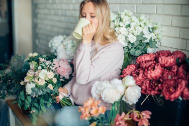 buket, yapım sürecinde kadın tutan onun elinde bir fincan kahve