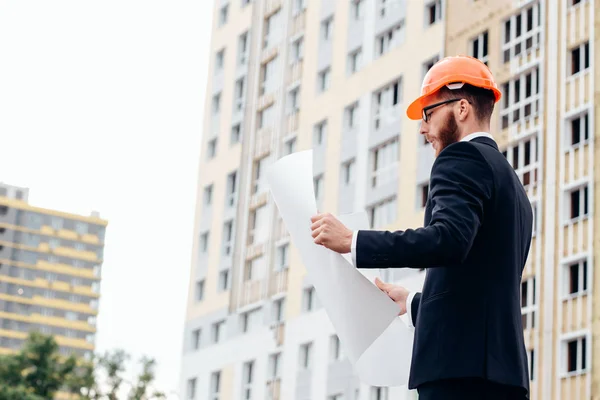 Retrato de um arquiteto construtor estudando plano de layout dos quartos — Fotografia de Stock