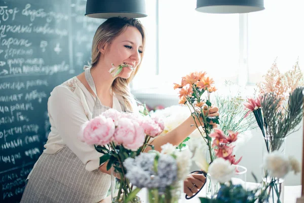 Florista toma una flor para hacer un ramo — Foto de Stock