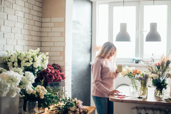 Hermosa florista empresaria reflexiva con taza de café sentado en la oficina — Foto de Stock