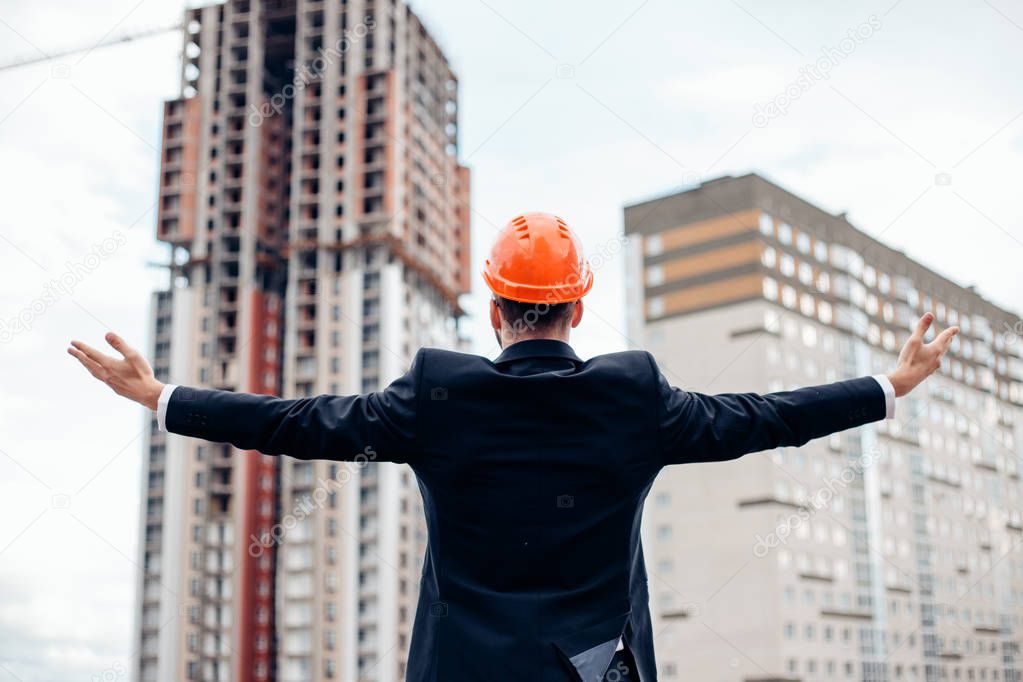 architect engineer dressed in a suit raises his hands a gesture of happiness