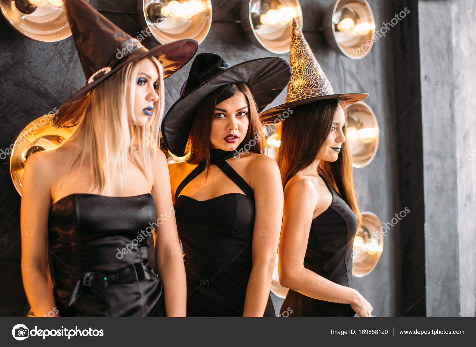 Tres mujeres jóvenes alegres en disfraces de Halloween bruja con