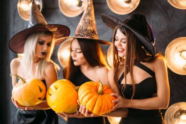 Cadı neşeli genç kadınlarda üç kabak ile Cadılar Bayramı kostümleri