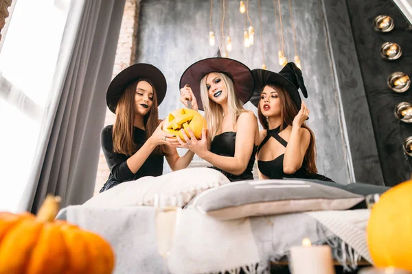 Tre donne adulte intagliano zucche di Halloween mentre ridono e danno una festa — Foto Stock