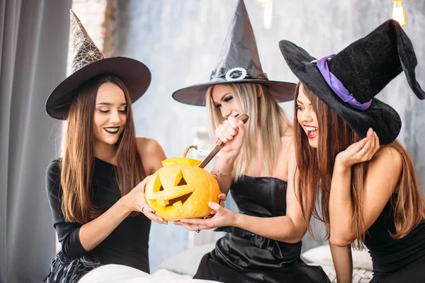 Three adult women carve Halloween pumpkins while laughing and having a party — Stock Photo, Image