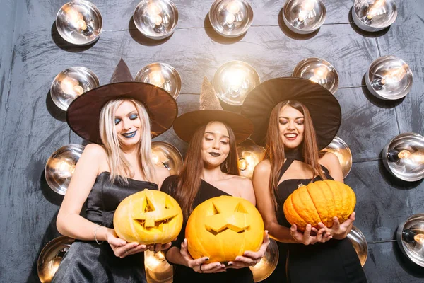 Trzy wesoły młodych kobiet w witch halloween kostiumy z dyni — Zdjęcie stockowe