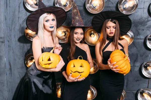 Cadı neşeli genç kadınlarda üç kabak ile Cadılar Bayramı kostümleri