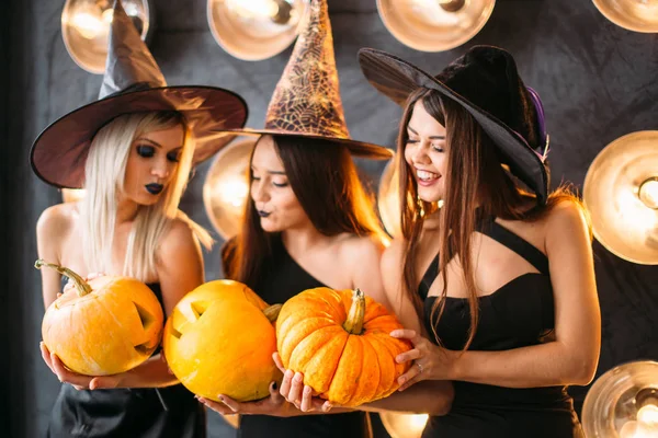 Cadı neşeli genç kadınlarda üç kabak ile Cadılar Bayramı kostümleri