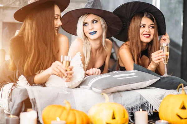 Group of creepy friends at the party lying at bed and drink champagne — Stock Photo, Image