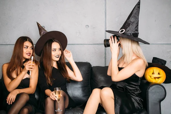 Jóvenes posando en sombreros de Halloween y con champán — Foto de Stock