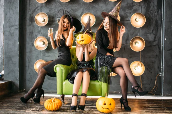 Three emotional young women in halloween costumes having fun on party — Stock Photo, Image