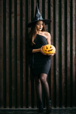 Cadılar Bayramı için kabak tutan genç sarışın kadın