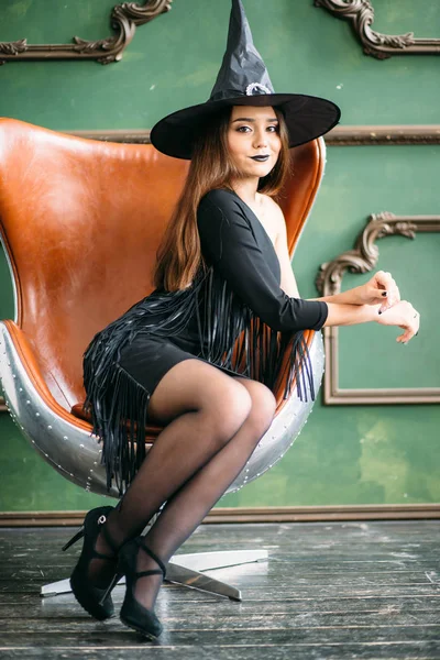 Emotional young women in halloween costumes sitting on chait — Stock Photo, Image