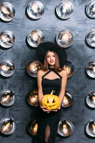 Jonge blonde vrouw met pompoenen voor halloween — Stockfoto
