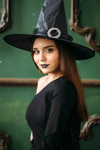 黒魔女の帽子と衣装の美しい若い女性 — ストック写真