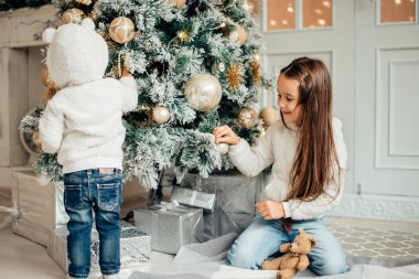 İki kız Noel Baba Noel ağacın önünde döşeme şapka