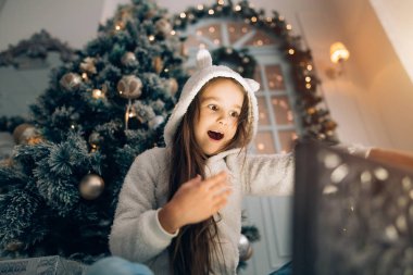 Sevimli küçük kız sihirli bir Noel hediyesi bir Noel ağacı tarafından açılış