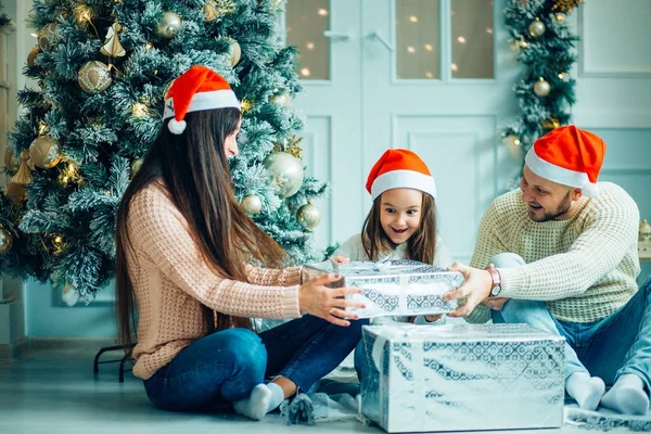 Lyckliga familjen mor och barn dotter på juldagsmorgonen med gåvor — Stockfoto