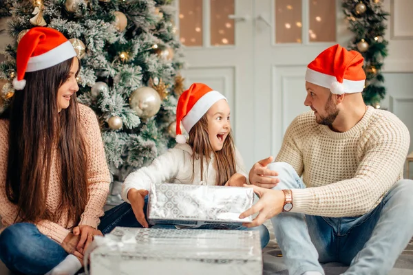Lyckliga familjen mor och barn dotter på juldagsmorgonen med gåvor — Stockfoto