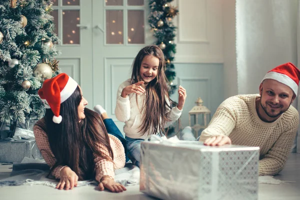 Lyckliga familjen mor och barn dotter på juldagsmorgonen med gåvor — Stockfoto