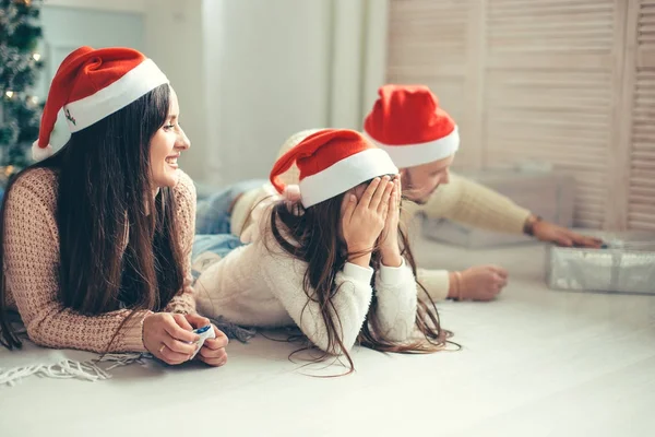 Lyckliga familjen mor och barn dotter på juldagsmorgonen med gåvor — Stockfoto