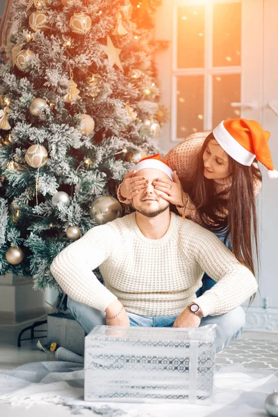 Ευτυχισμένο ζευγάρι στην το καπέλο Santa με τα Χριστούγεννα και το νέο έτος δώρο στο σπίτι — Φωτογραφία Αρχείου