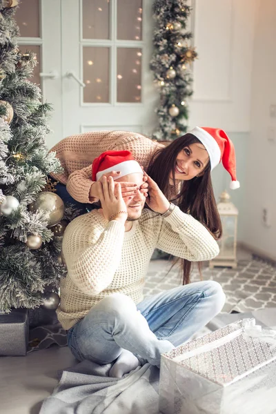 Lyckliga paret i Tomtemössa med jul och nyår gåva hemma — Stockfoto