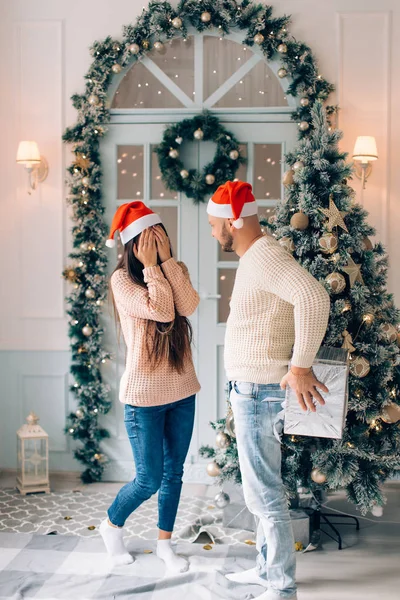 Par med nuvarande ler försiktigt kramar på julbelysning — Stockfoto